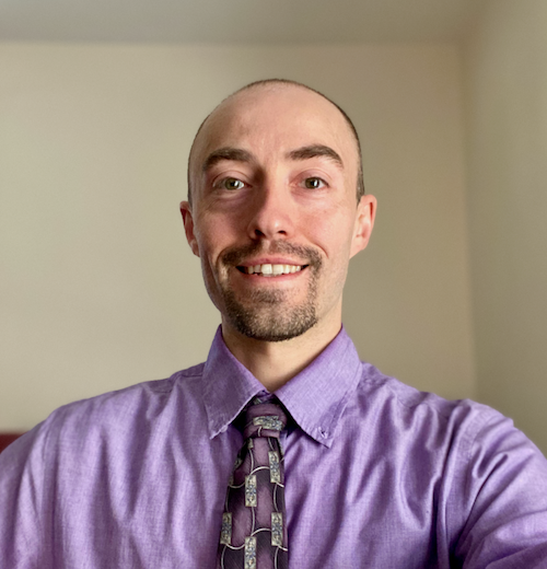 headshot of Geoffrey Johnson, a white male wearing purple shirt and tie